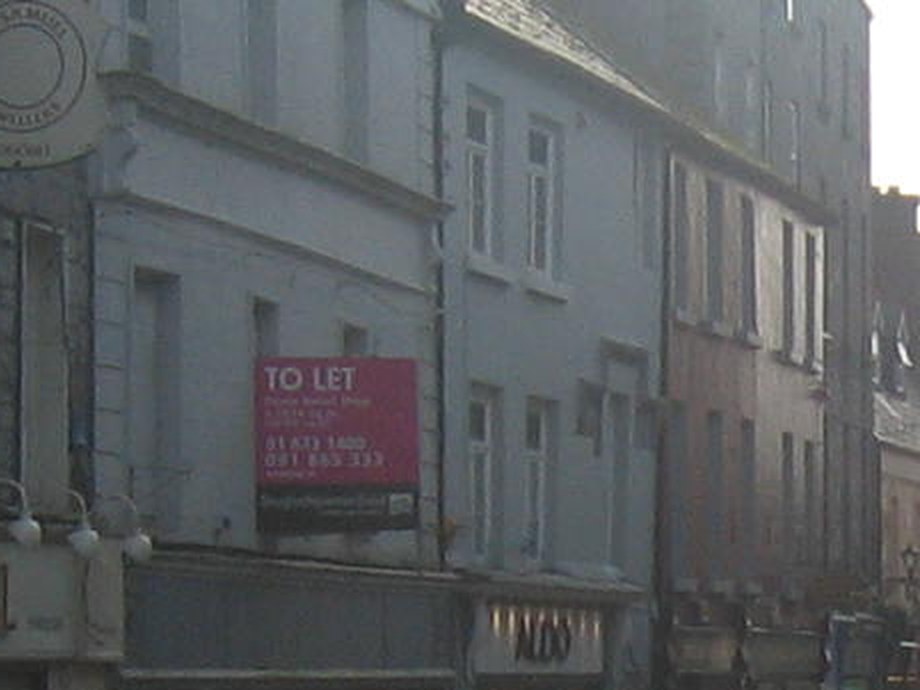 A TO LET sign on a grey shopfront, with nobody in sight